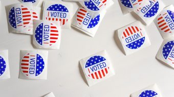 "I voted" stickers scattered across a white tabletop.