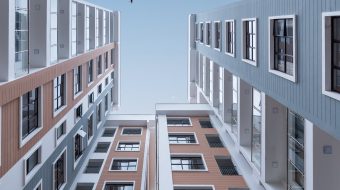 View looking up at a group of tall apartment buildings.