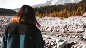 Woman looking at a dry, rocky landscape.