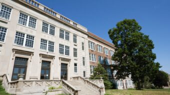 white and red brick school building surrounded by trees and blue sky; represents a washington public school in this context